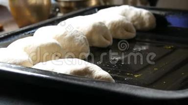 女人的手面包师把自制的烘焙面团以细长的<strong>圆球</strong>的形式连续放置在黑色烘焙片上